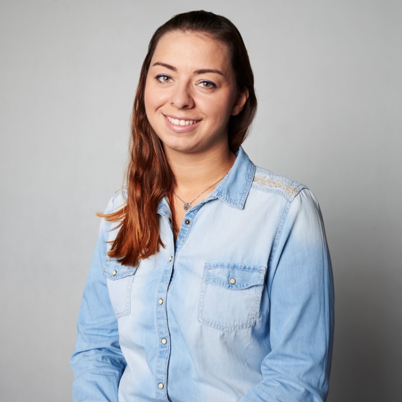 Zdjęcie portretowe: Wioletta Boczar-Dominiak. Patrzy w obiektyw i uśmiecha się. Ubrana w dżinsową koszulę.